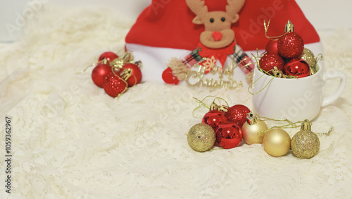 Assorted red and gold glittered Christmas baubles and a reindeer ornament on lace invoking a festive holiday mood