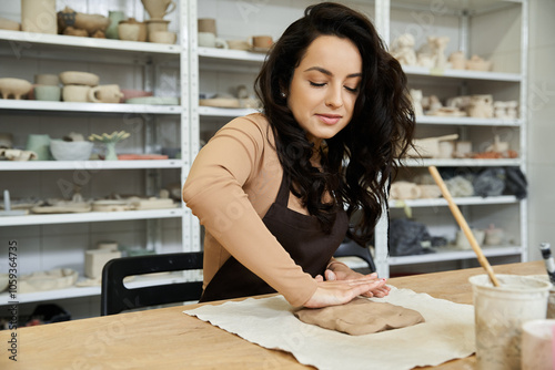 Pretty woman at table making pottery.