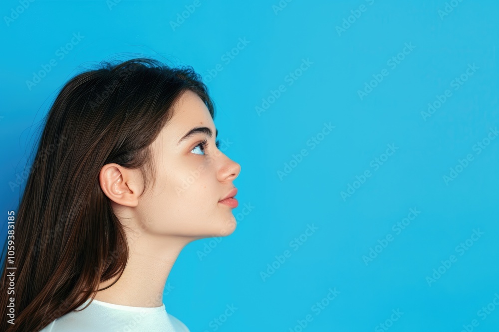 Attractive girl showing copy space on blue background portrait. Attractive girl showing copy space on blue background portrait.