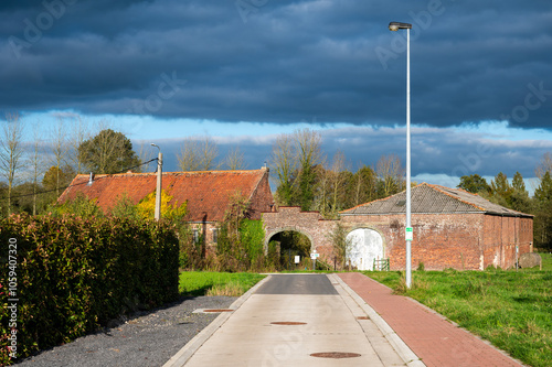 Perspective view over old brick stone farmhouse at the Flemish countryside in Sint Martens Lennik, Flemish Brabant, Belgium photo