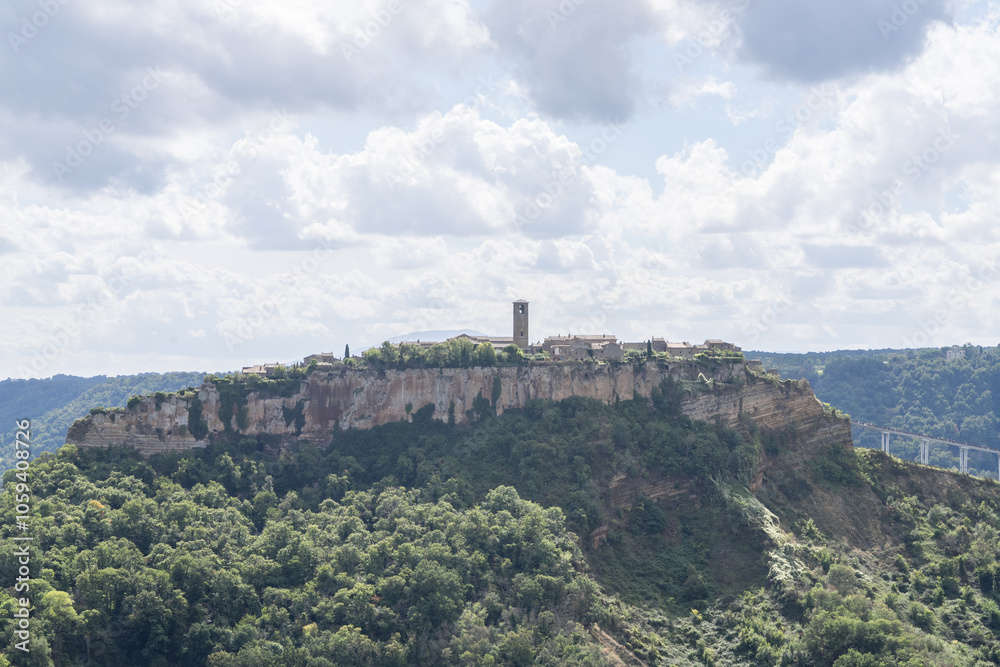 Fototapeta premium Bagnoregio, Italy - September 28 2024: Panoramic view on Civita di Bagnoregio. Picturesque Ancient Hilltop Etruscan era village with Historic Architecture and Stunning Panoramic Views. Italian summer.