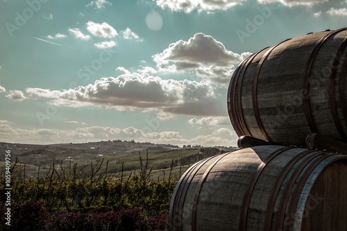 Scenic Landscape with a Stack of Rustic Barrels in a Vibrant Field Under a Blue Sky