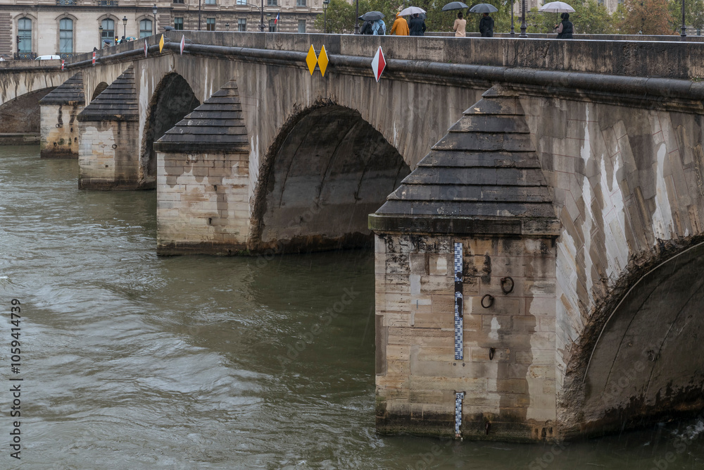 A rod with measurements in meters is applied to a pylon of the Pont Royal bridge in Paris, France, to control the flooding of the Seine River in the rain A rod with measurements in meters is applied to a pylon of the Pont Royal bridge in Paris, France, to control the flooding of the Seine River in the rain