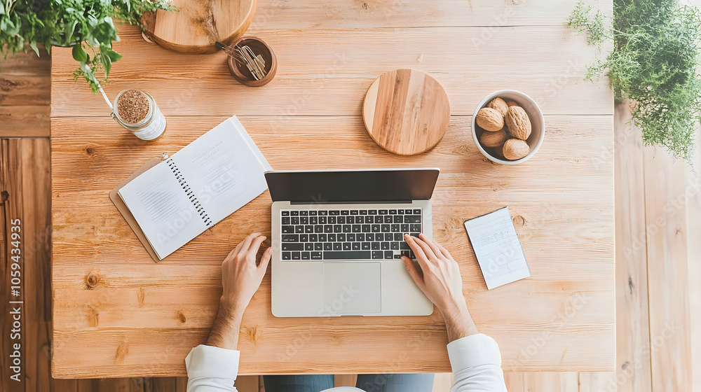 Remote work setup with laptop, notebook, and snacks on wooden table Remote work setup with laptop, notebook, and snacks on wooden table