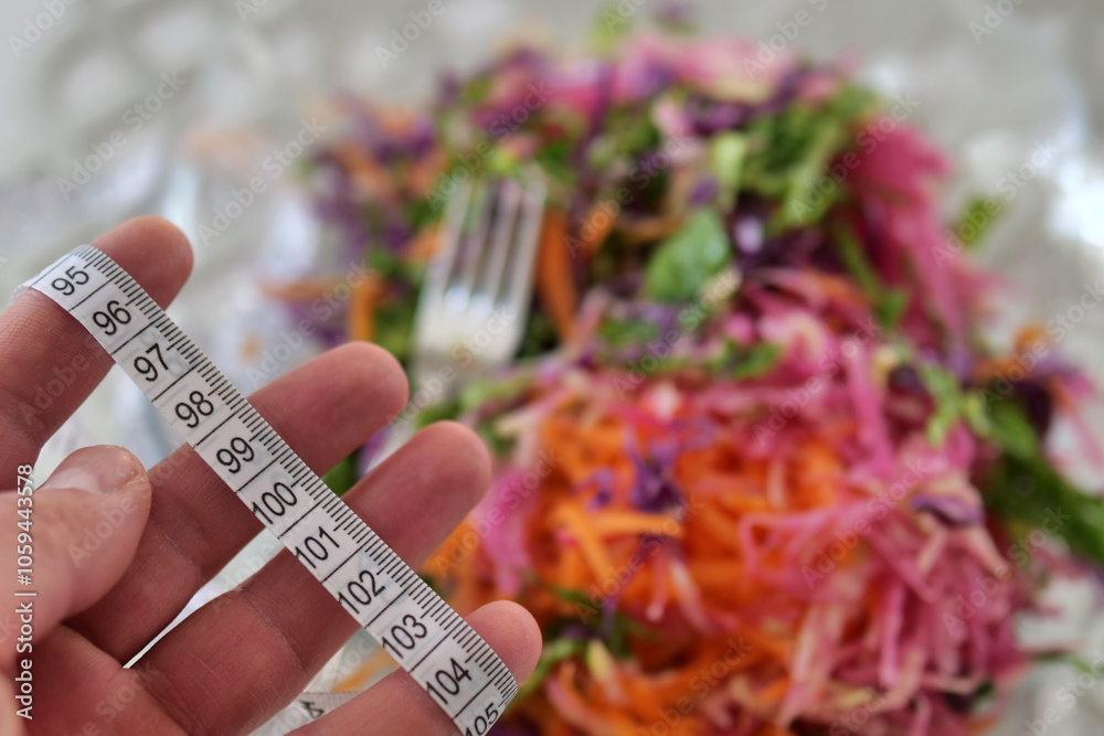 Losing weight with salad, there is a tape measure and salad next to it, a person trying to lose weight,