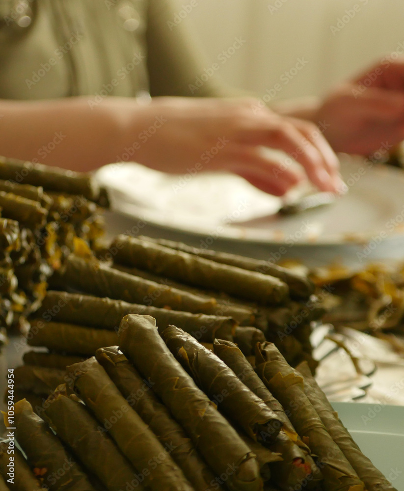 A housewife wraps homemade vine-grape leaf stuffing,