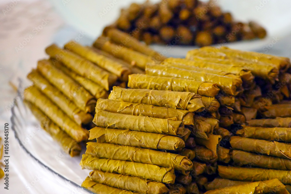 Homemade stuffed vine leaves are arranged in a row on the table,
