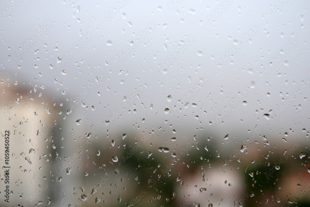Raindrops falling on the balcony glass, raindrops sliding off the glass,