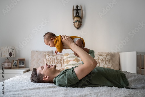 Father playing with newborn photo