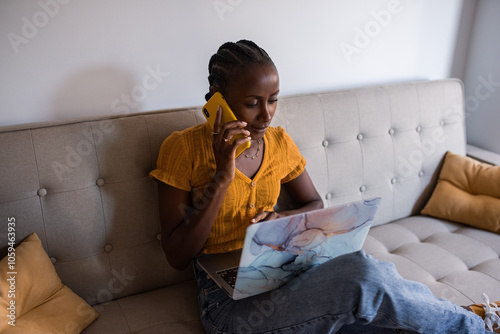 Young woman using gadgets on couch at home photo