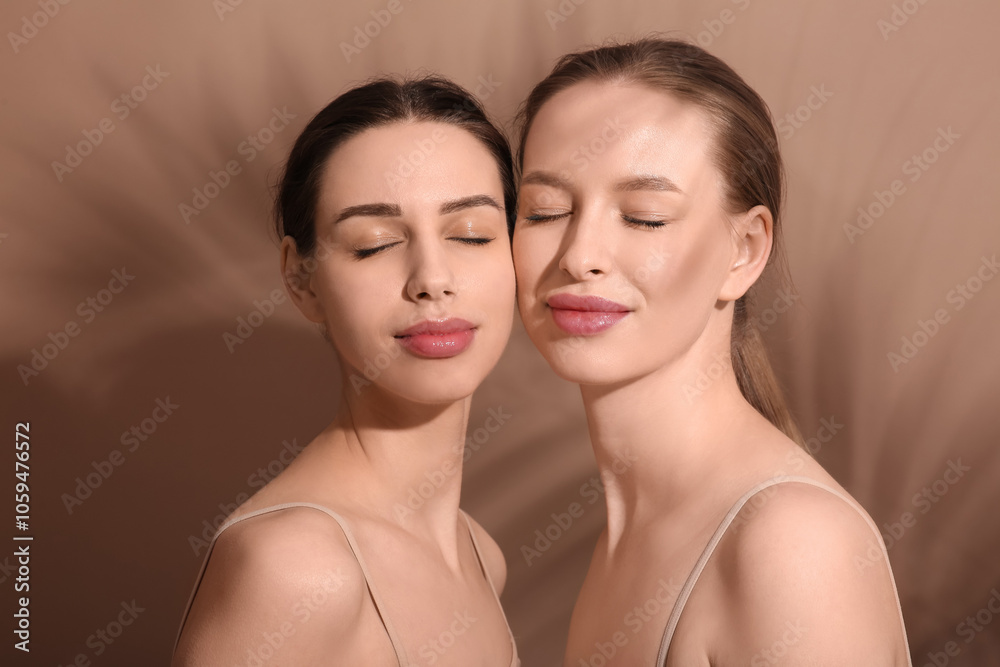 Beautiful young sisters on brown background Beautiful young sisters on brown background