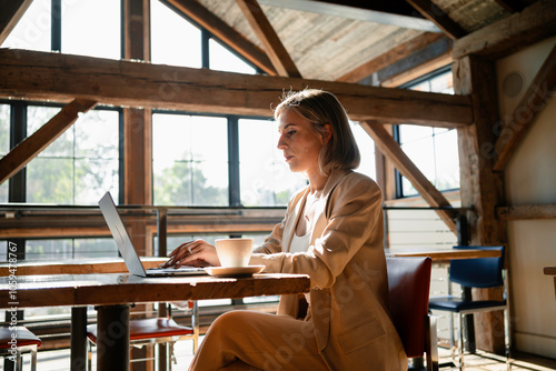 A woman uses a laptop in a cafe