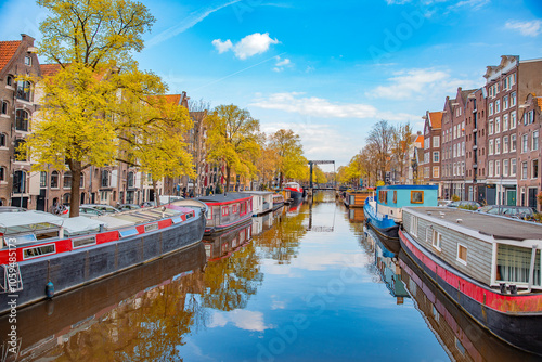 Canvas Print houses by a water canal in Amsterdam in autumn.