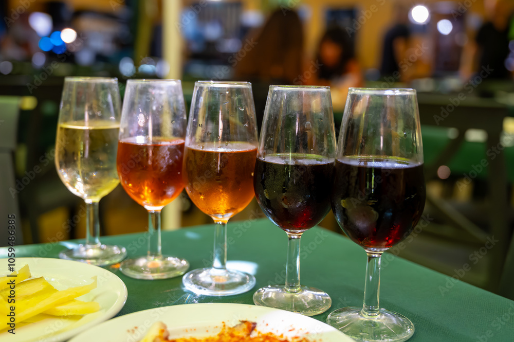 Fototapeta premium Tasting of sherry wines from barrels, fino, manzanilla, olorosso, amontillado jerez wines with traditional Andalusian tapas in old tavern, Sanlucar de Barrameda, Cadiz, Andalusia, Spain