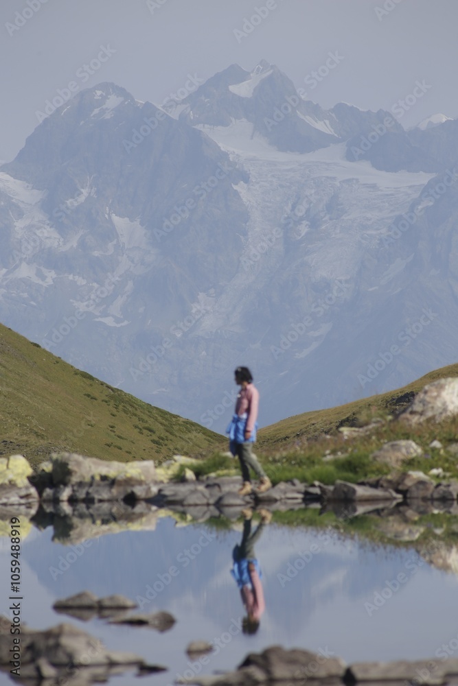 Obraz premium Peaceful Mountain Reflection with Hiker in Alpine Landscape VSCO