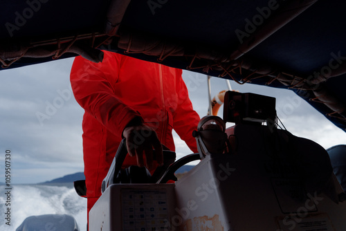 Man With Orange Overalls Driving Boat photo