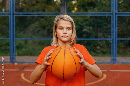 Boy holding ball in front of him and looking at camera photo