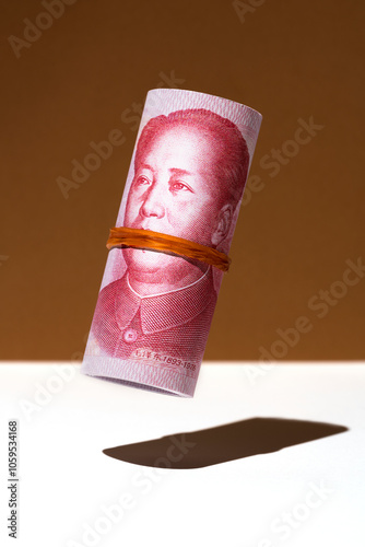 Chinese yuan money roll hovering on brown and white background photo