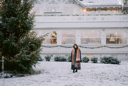 Woman beside a decorated outdoor Christmas tree photo