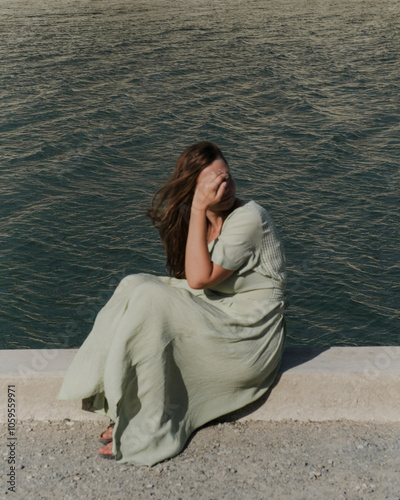 A girl sitting near the water photo