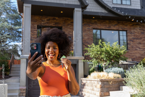 Proud young black woman portrait  front of new house selfie  photo