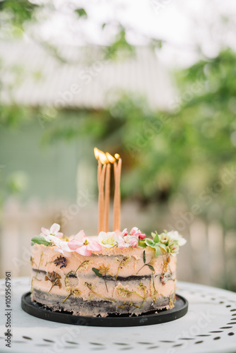 Artistic cake with candles and floral decorations. photo