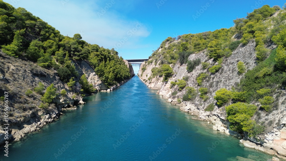 Fototapeta premium The famous Corinth Canal in Greece during a hot and sunny summer day. Artificial canal that connects the Gulf of Corinth with the Saronic Gulf. It separates the Peloponnese from the Greek mainland.