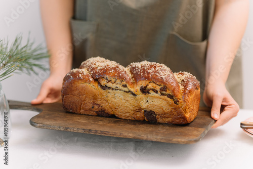 Holding freshly baked bread loaf on a wooden tray photo