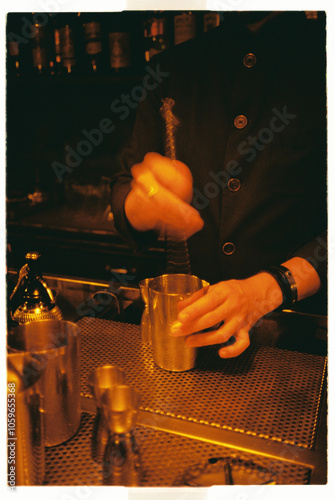 Crop bartender hands mixing cocktail with bar spoon
 photo