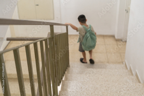 Boy Descending Stairs With Backpack photo