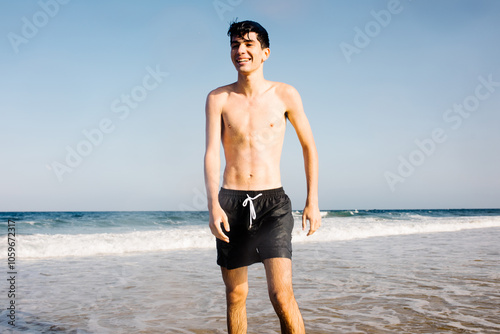 Teenager enjoys a summer day soaking in the ocean waves at the beach photo