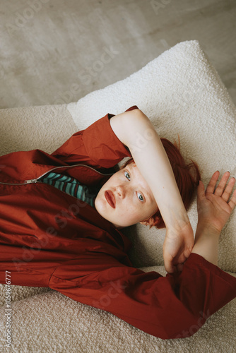 Tired woman lying on sofa and looking at camera photo