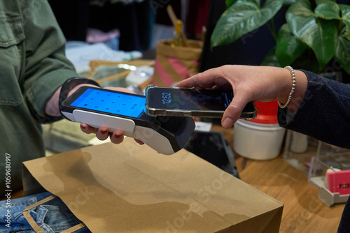 Customer making a payment with phone at a retail store counter
