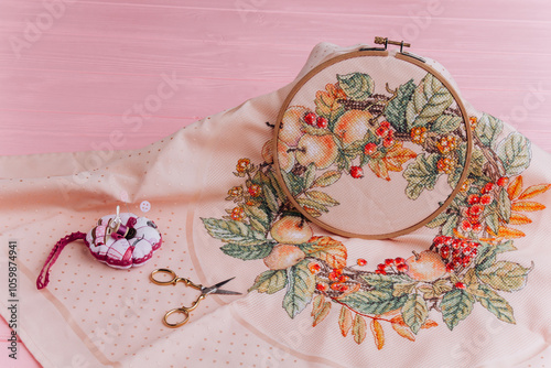 Close-up image of embroidery hoops with floral design and scissors in gold color, perfect for illustration of handmade textile art and creativity. photo