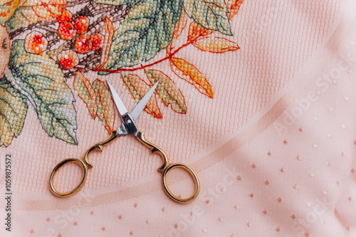 Close-up image of embroidery hoops with floral design and scissors in gold color, perfect for illustration of handmade textile art and creativity. photo