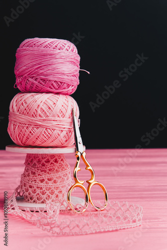 Close-up of balls of yarn and ribbon next to beautiful iron scissors, perfect for knitting, crocheting and DIY project inspiration.