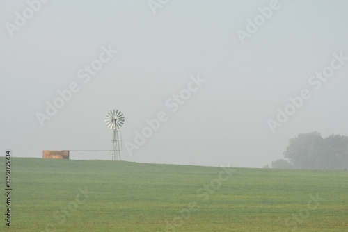 Landscape with a Windmill water pump with morning fog monochrome photo