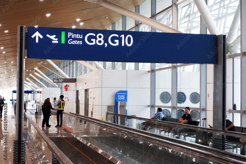 Obraz premium KLIA T1 or Kuala Lumpur International Airport Terminal 1 boarding gate signage on top of the moving walkways or travelator and people in the waiting area for international flight or delay in flight. d