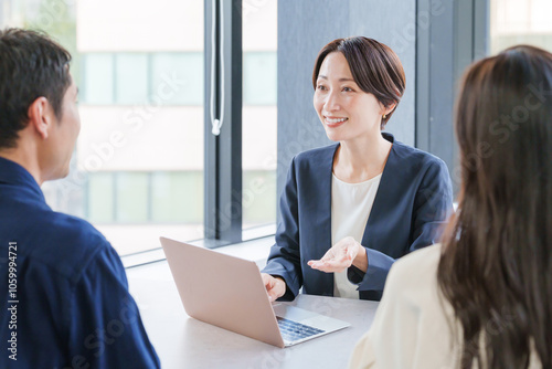 不動産の女性営業マンと客夫婦 photo