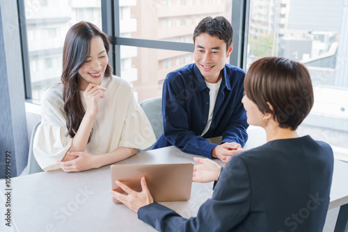 不動産の女性営業マンと客夫婦 photo