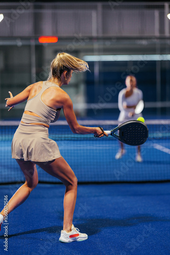 Obraz na płótnie Rear view of an athletic young woman playing padel