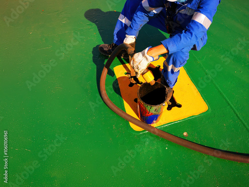 a ship crew is working or chipping during maintenance period on a cargo ship