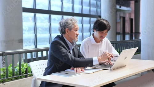 Asian senior professor is giving advice to the college student on the research thesis while sitting in the university faculty for education, academic and business