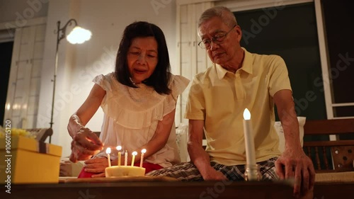 Senior asian couple is happily celebrating birthday together at home for love, relationship, bonding, longevity and marriage concept	