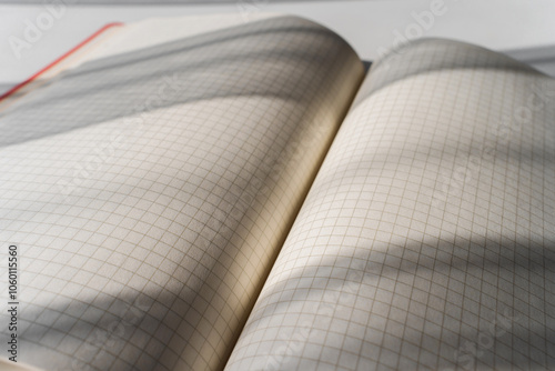 Open Notebook with Grid Pages and Soft Shadows from Natural Light