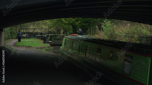 STOKE-ON-TRENT, STAFFORDSHIRE, ENGLAND - OCTOBER 30 2024: Man and woman opening a lock on the Caldon canal whilst a child drives the narrowboat sequence 3 of 3. photo