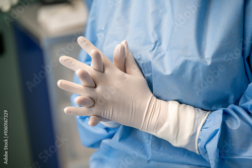 mains d'une chirurgienne avec des gants avant une opération en tenue de bloc photo