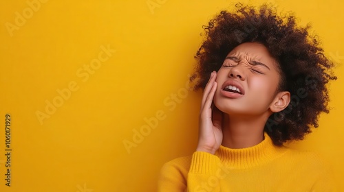 Person wincing in pain, hand to ear, medical background, experiencing ear ringing photo