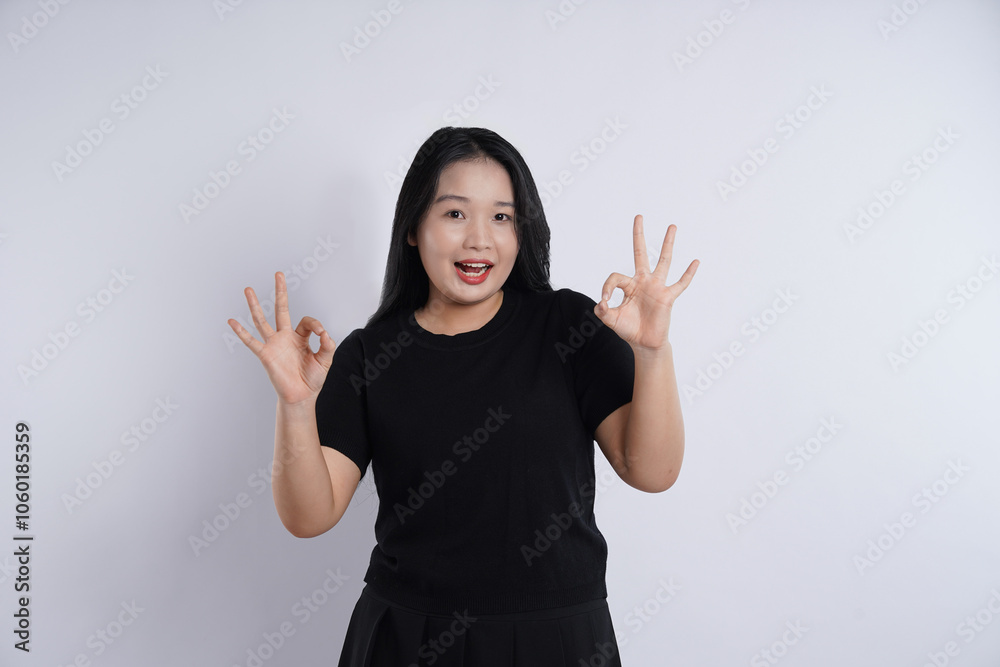 Young, obese, plus-sized Asian girl wearing black t-shirt posing against plain white background Young, obese, plus-sized Asian girl wearing black t-shirt posing against plain white background