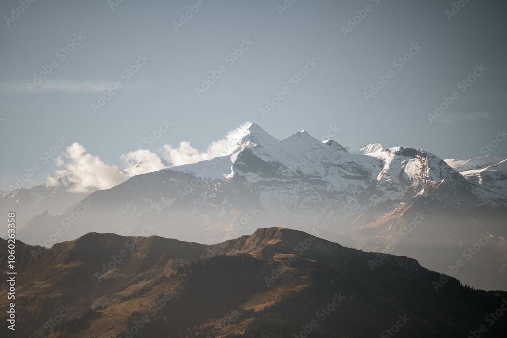 Obraz premium Breathtaking sunrise over foggy mountain landscapes, casting warm light through misty valleys. A serene and majestic scene, perfect for outdoor, nature, and adventure themes capturing dawn's beauty.